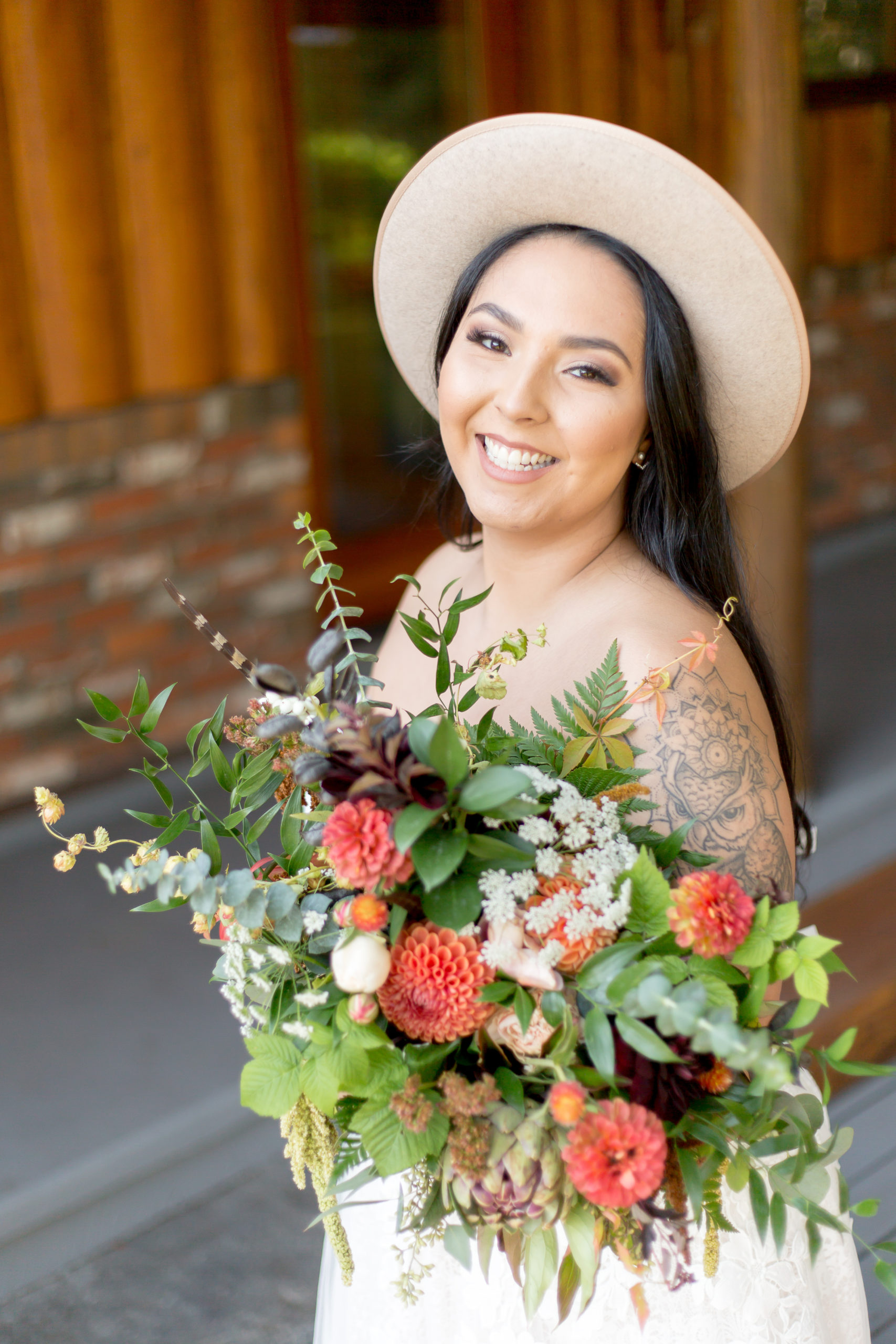 Bride smiles at her BC wedding photographer while holding her bouquet during her elopement