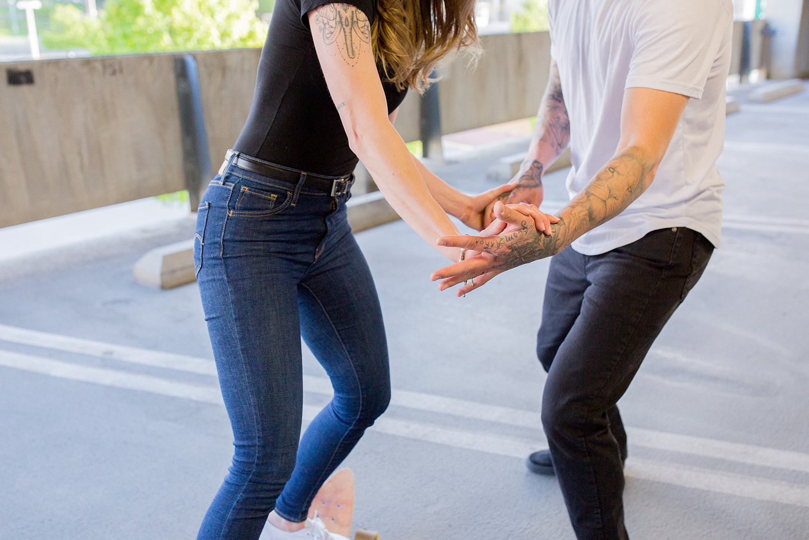 Couple goofs off on a skateboard in front of their photographer during their photoshoot