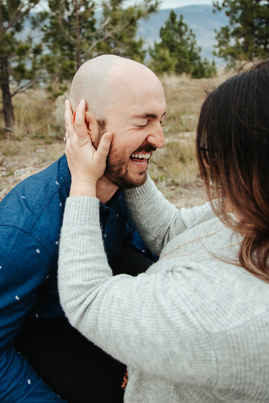 couple shares a laugh in the grass during their outdoor engagement photoshoot in BC