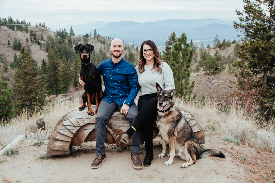 newly engaged couple sits with their two dogs during their engagement photoshoot in BC