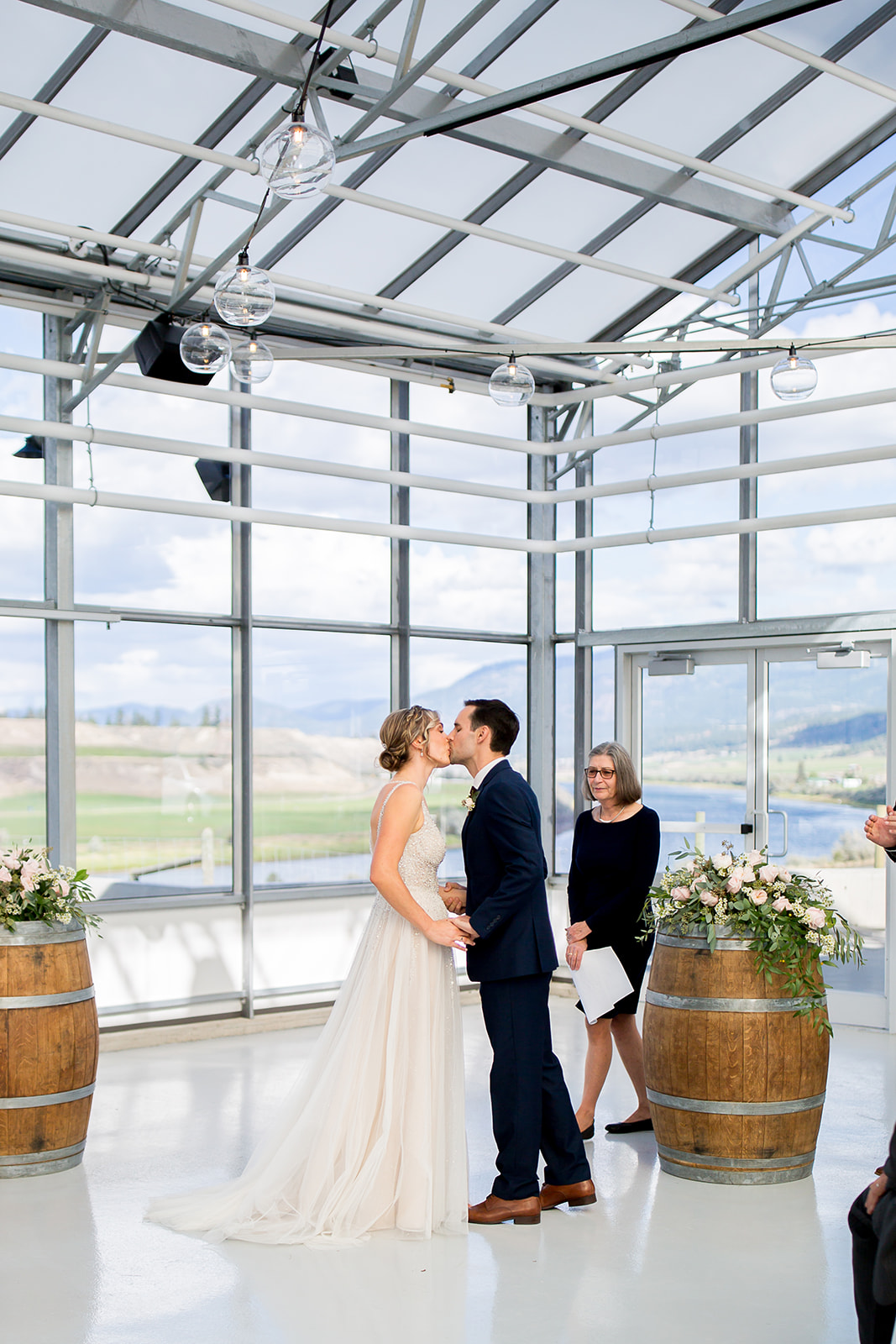 Bride and groom share a kiss inside their winery wedding venue after saying "I do"