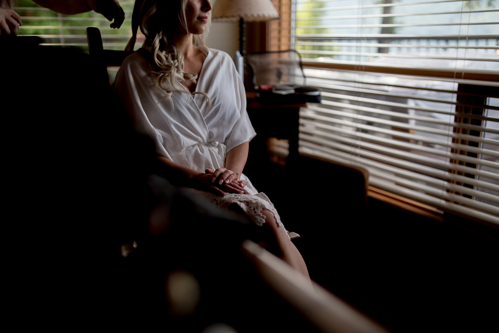 bride looking out the window while getting ready for her wedding day, here are 10 tips for the morning of your wedding