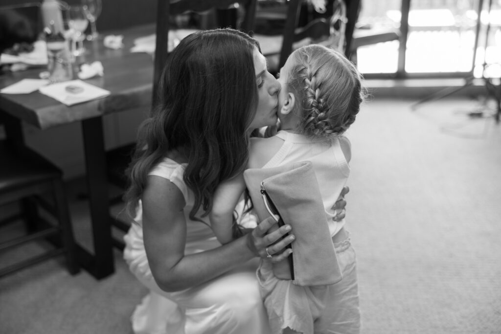 documentary photography of bride embracing flower girl at four seasons resorts whistler