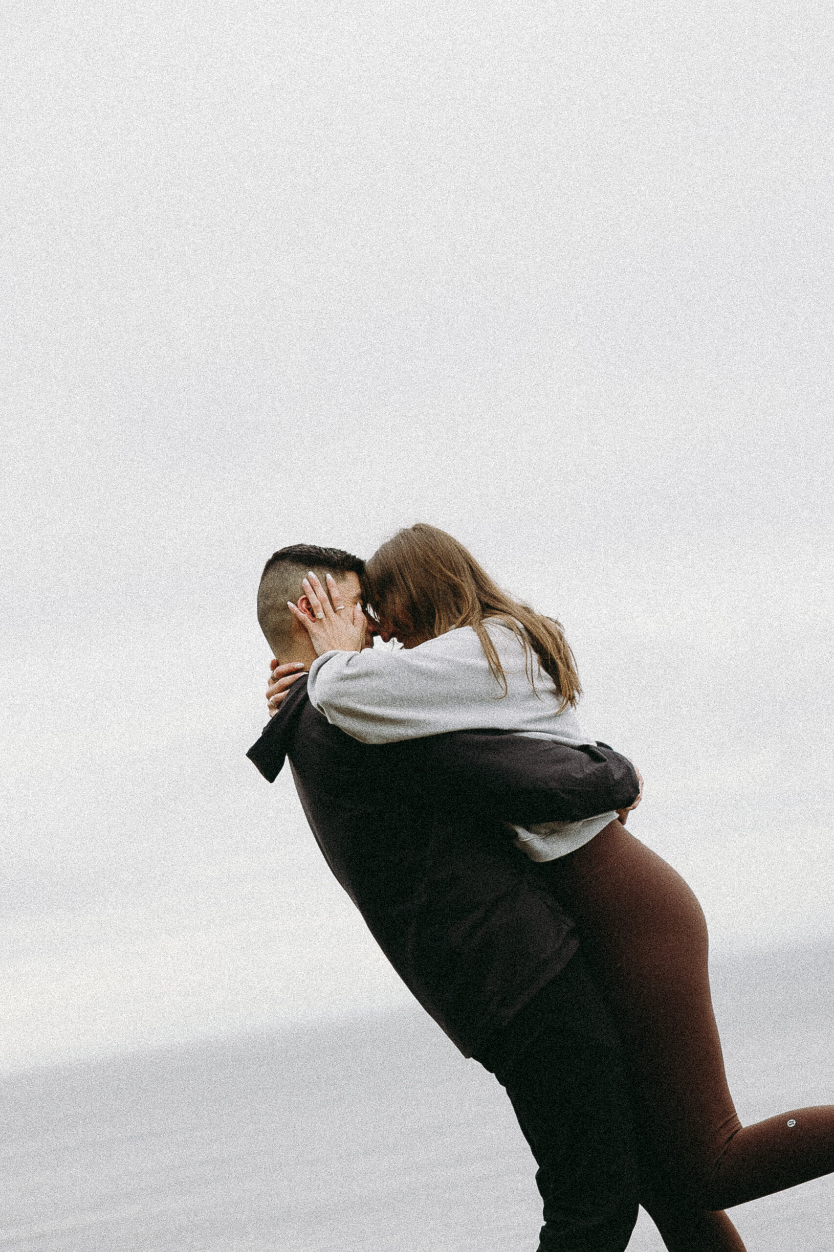 couple hugging after wedding proposal at lighthouse park