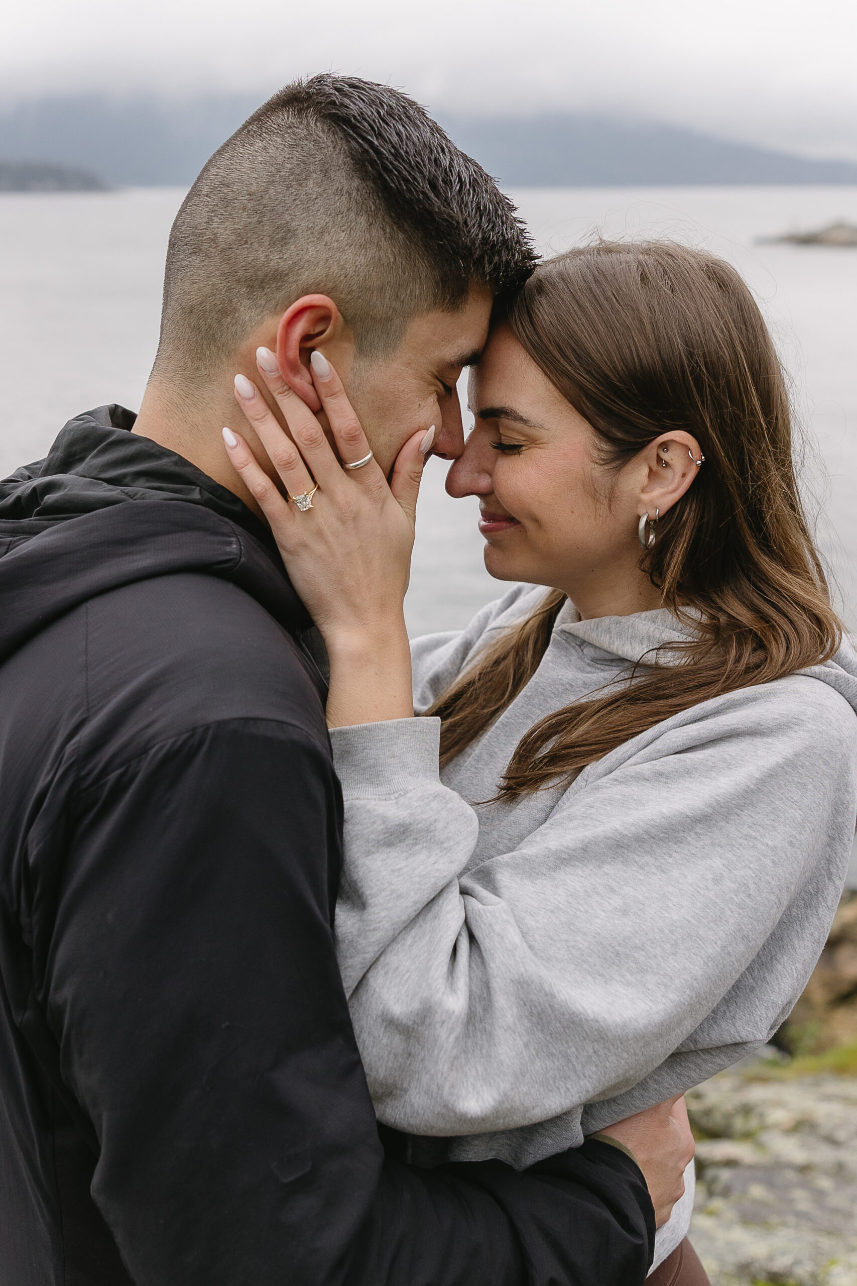 couple embracing after wedding proposal at lighthouse park vancouver