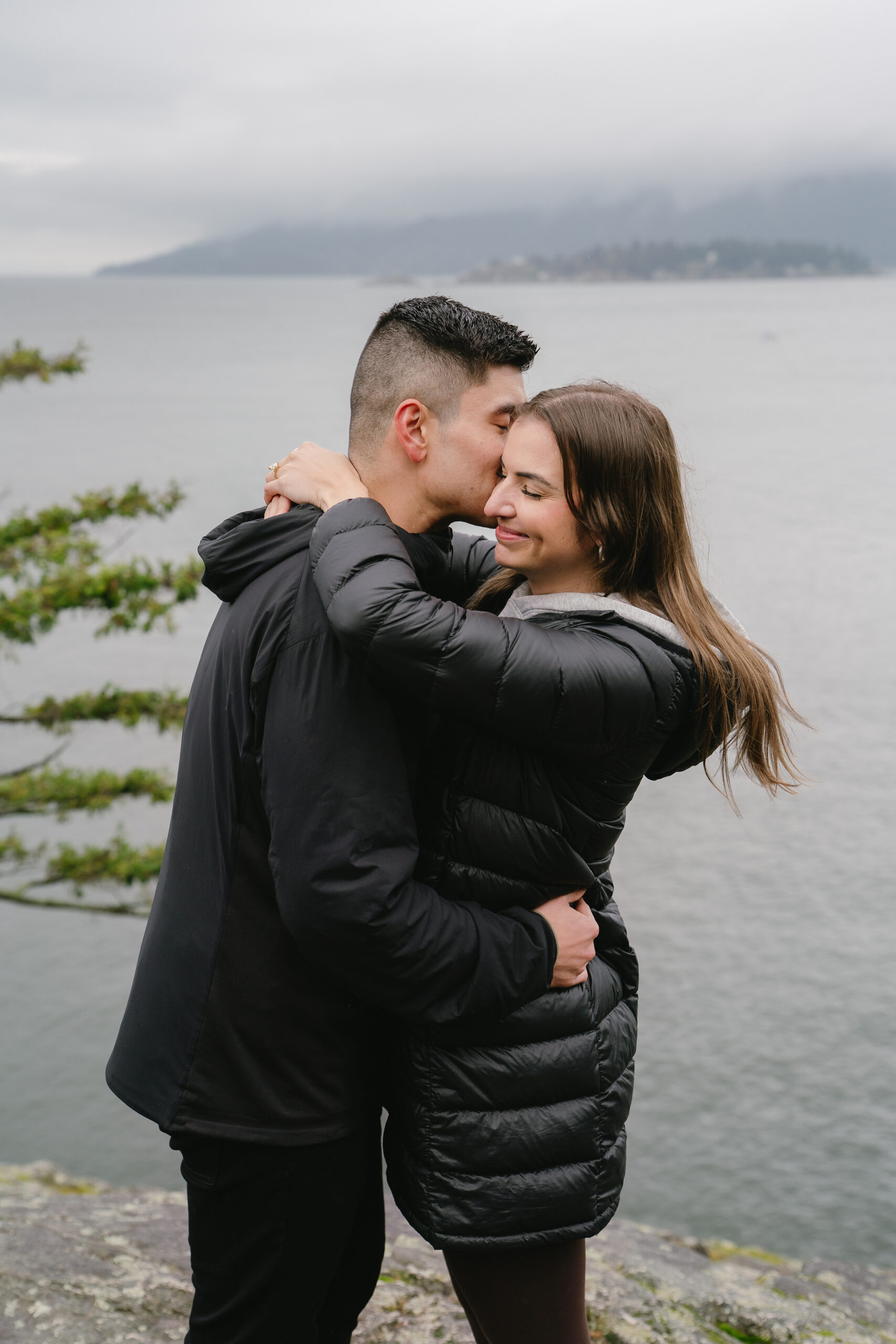 couple hugging after vancouver proposal at lighthouse park