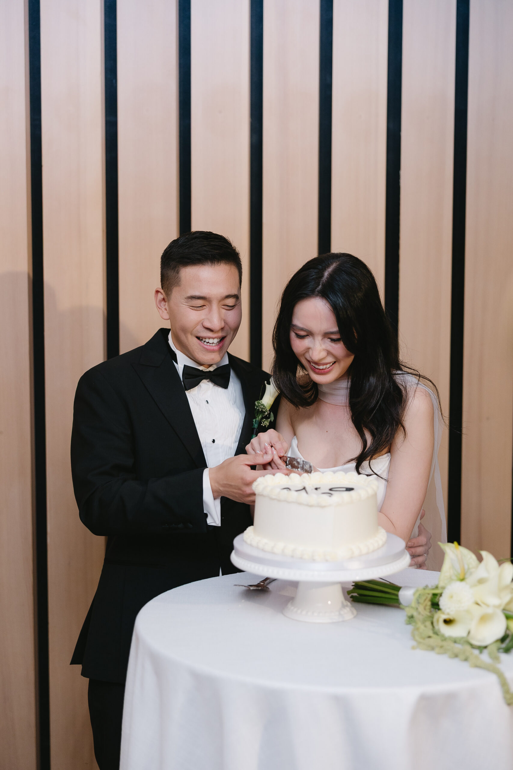 bride and groom cutting the cake at their reception at the audain art museum in whistler
