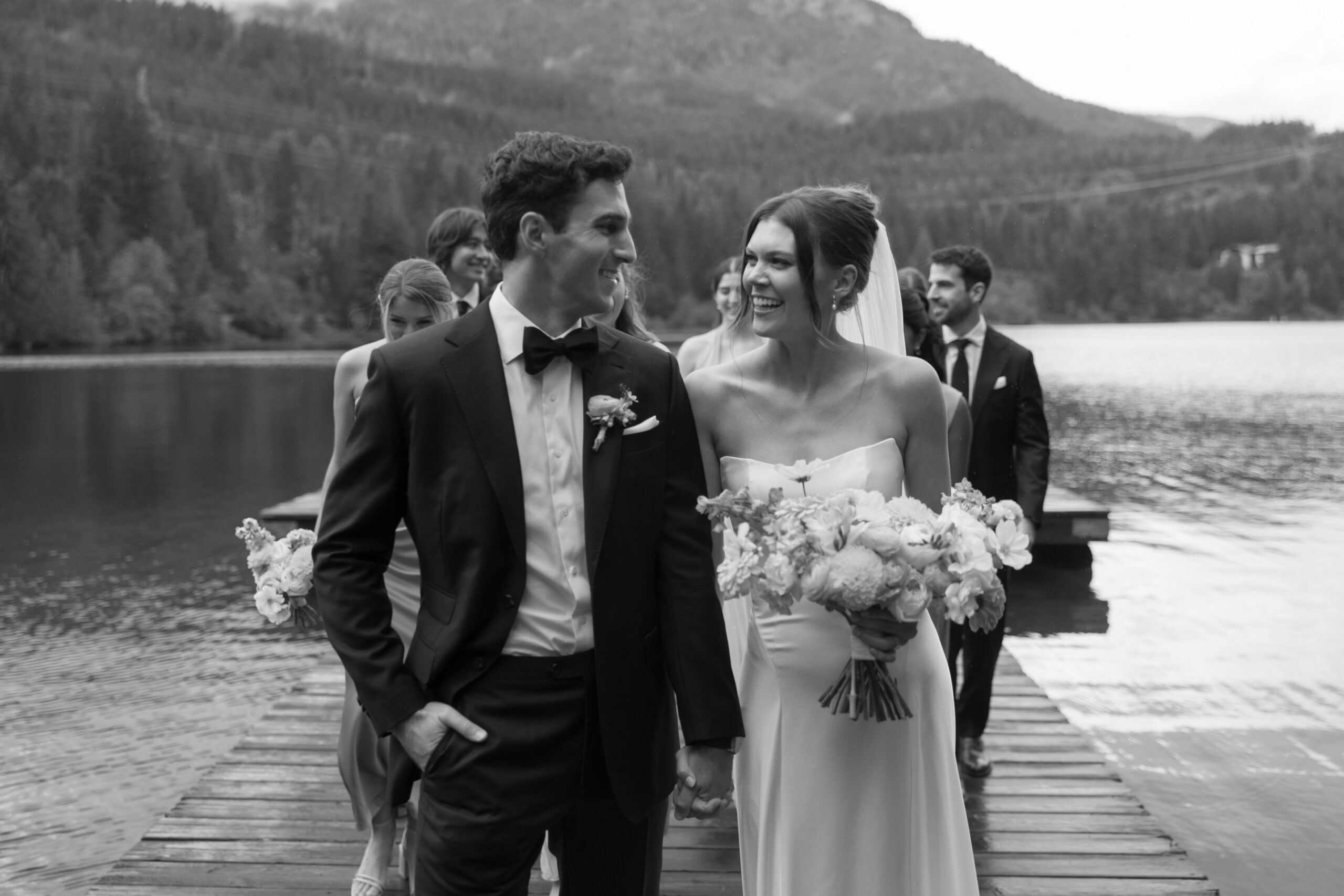 wedding party walking on the docks at nita lake lodge after wedding ceremony